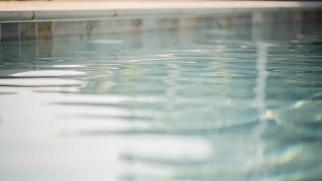 Close view of clear pool water moving over pale plaster